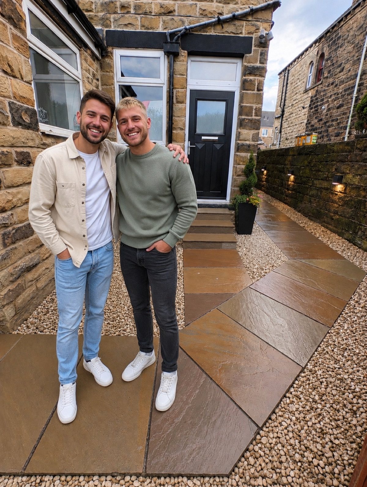 Homeowners in a stone courtyard with an Eaton composite door in Black